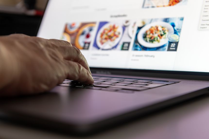 A person on a laptop shopping for groceries and food online