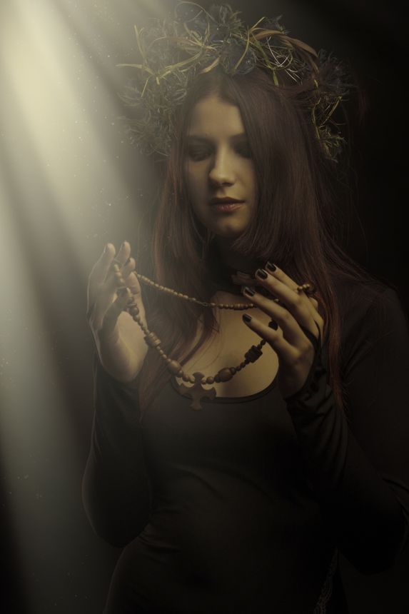 Beautiful woman in wreath over dark background