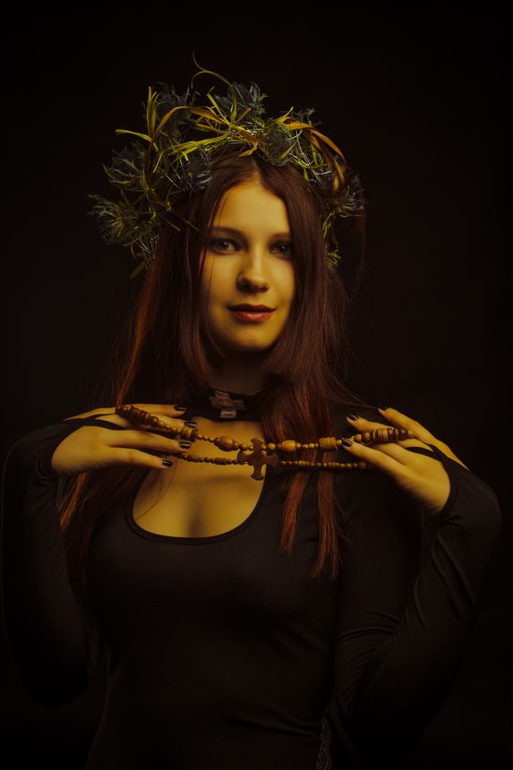 Beautiful woman in wreath over dark background